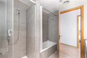 a bathroom with a bath tub and a shower at The Corner Apartments by Aspasios in Barcelona