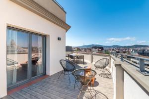 einen Balkon mit Stühlen und Stadtblick in der Unterkunft The Corner Apartments by Aspasios in Barcelona