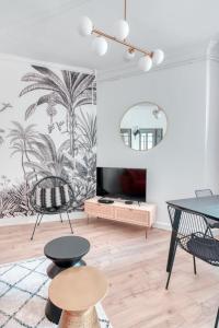 Una sala de estar con una mesa y sillas y un espejo. en GuestReady - Aptos modernos em Lyon, en Fourvière