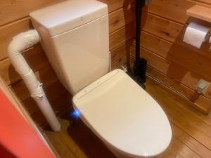 um banheiro com um vaso sanitário branco em um quarto em モリソンヴィラ 石垣のログハウス em Shiso mais 25 fotografias