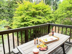 uma mesa de madeira com uma bandeja de comida numa varanda em モリソンヴィラ 石垣のログハウス em Shiso