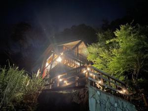 uma casa iluminada à noite com luzes em モリソンヴィラ 石垣のログハウス em Shiso