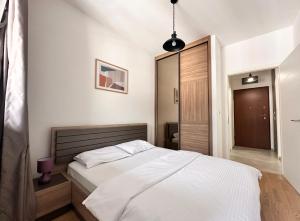 a bedroom with a white bed and a mirror at Mediterranean Apartment 2 in Budva