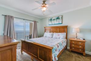 a bedroom with a bed and a dresser and a window at Crystal Shores West Condos in Gulf Shores