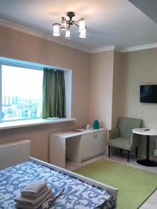 a bedroom with a bed and a desk and a window at Bon Mary Hotel in Astana