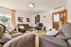 ein Wohnzimmer mit zwei Sofas und einem Fernseher in der Unterkunft Villas Guzman - Stefka in Calpe