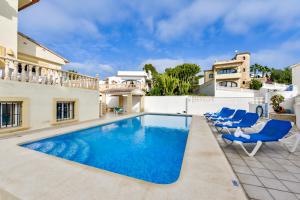 Villa mit einem Pool und blauen Stühlen in der Unterkunft Villas Guzman - Stefka in Calpe
