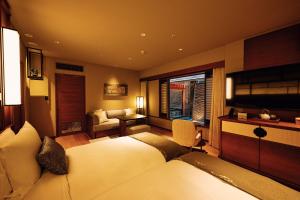 a bedroom with a large bed and a couch at Sora Niwa Terrace Kyoto Bettei in Kyoto