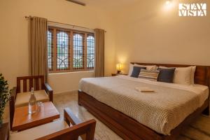 a bedroom with a large bed and a window at StayVista at Spice Notes - Breakfast Included in Munnar