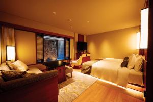 a hotel room with a bed and a couch at Sora Niwa Terrace Kyoto Bettei in Kyoto