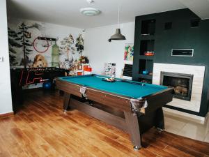 a living room with a pool table and a fireplace at Willa Pachówka - tam, gdzie natura spotyka się z nowoczesnością in Bukowina Tatrzańska