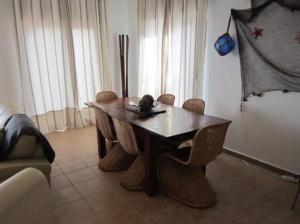 a dining room with a table and chairs and a couch at Marina del Este sea view half villa in Almuñécar +5 photos