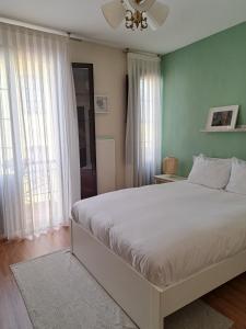 ein Schlafzimmer mit einem großen weißen Bett mit grünen Wänden in der Unterkunft Apartamento Sabugo in Avilés