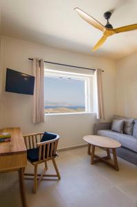 a living room with a couch and a window at Alma Sunset Suites in Ios Chora