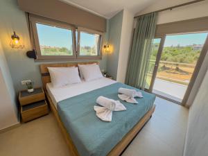 a bedroom with a bed with two towels on it at B Cozy Apartments in Limenaria