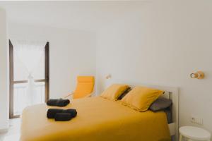 een slaapkamer met een geel bed met een oranje stoel bij Happy House - Downtown Apartment in Corralejo
