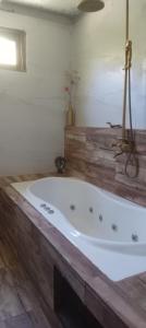 a large bath tub in a bathroom with wooden floors at Hostal SPA Casa de Piedra in La Quebrada