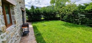 ein grasbewachsener Hof mit zwei Bänken neben einem Gebäude in der Unterkunft La Casina de Mestas de Con - Con jardín exterior - VV-2903-AS in Con