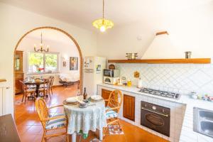 a kitchen with a table and a dining room at Villa Maria Luisa vista mare, Palinuro - Happy Rentals in Palinuro