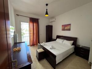 a bedroom with a large bed and a window at Angels Rooms in Ksamil