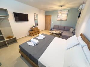 a bedroom with a large bed and a couch at B Cozy Apartments in Limenaria