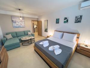 a bedroom with a large bed and a couch at B Cozy Apartments in Limenaria