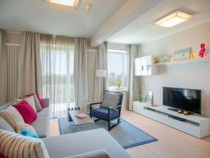 Una sala de estar con un sofá y un televisor. en Dünenresidenz Prora - Ferienwohnung mit Meerblick, 2 Schlafzimmern, Sauna und Balkon NP-404, en Binz