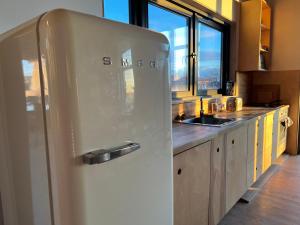 a white refrigerator in a kitchen with a sink at Villa Les Terrasses in Ezerets
