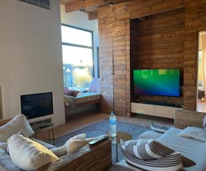 a living room with a couch and a flat screen tv at Villa Les Terrasses in Ezerets +19 photos