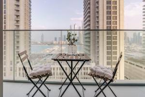 Una mesa y dos sillas frente a una ventana. en GuestReady - Beach Vista in Marina Harbour, en Dubái