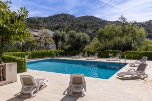 a pool with chaise lounge chairs and a swimming pool at Bellavista Attic in Port de Soller