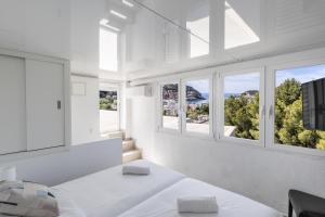 a bedroom with white walls and windows with a view at Bellavista Attic in Port de Soller +15 photos