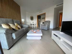 ein Wohnzimmer mit Couch und Fernseher in der Unterkunft Beach Albir in Albir
