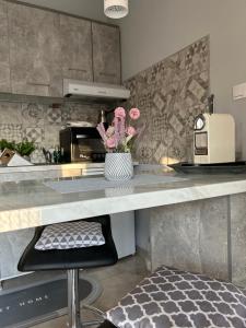 a kitchen with a counter with a vase of flowers at Pefkohori Beautiful Nest free parking 3 adults in Kassandra