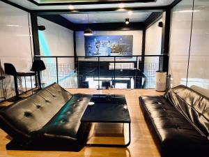 un soggiorno con un divano in pelle e una TV di The Lab Sleep Hostel a Chiang Rai