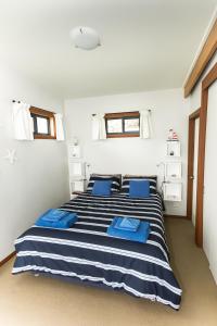A bed or beds in a room at Larus Waterfront Cottage