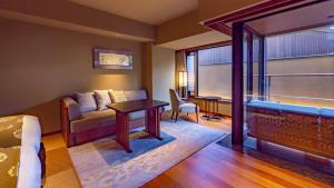 a living room with a couch and a table at Sora Niwa Terrace Kyoto Bettei in Kyoto