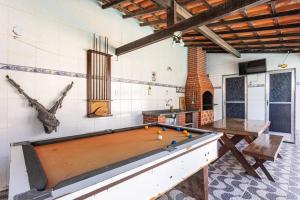 a ping pong table in a room with a pool table at Casa Privativa com Piscina, Churrasqueira, Mesa de Sinuca in Iguaba Grande