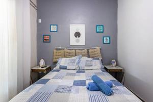 a bedroom with a blue and white bed with blue pillows at Casa Privativa com Piscina, Churrasqueira, Mesa de Sinuca in Iguaba Grande