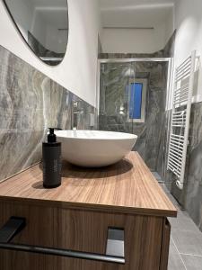 a bathroom with a white bowl sink on a wooden counter at appartamento Pekoe in Modena +19 photos