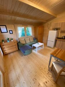 a living room with a couch and a refrigerator at Domek pod Brzozą in Sianów