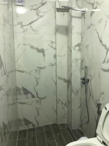 a bathroom with a glass shower with a toilet at Mona's guesthouse in Sarandë +65 photos