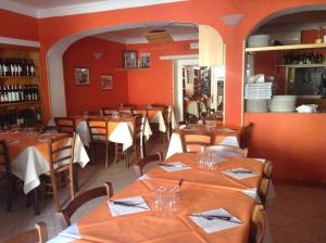a restaurant with tables and chairs in a room with orange walls at Hotel La Rosa in San Piero in Campo