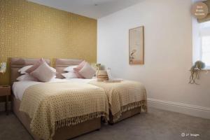 a bedroom with two beds and a clock on the wall at Luxury Coastal in St Ives