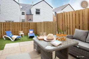a patio with a table and chairs and a fence at Luxury Coastal in St Ives