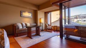 a living room with a couch a table and a fireplace at Sora Niwa Terrace Kyoto Bettei in Kyoto