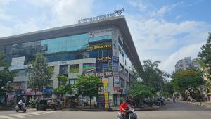 a man riding a motorcycle in front of a building at Hotel SERENE STAY in Surat