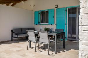 a dining room with blue cabinets and a table and chairs at Apartma Stara Maslina in Rab