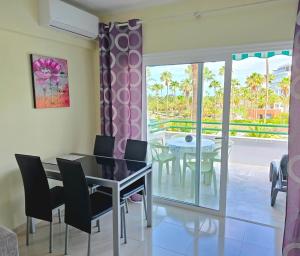 a dining room with a table and chairs and a balcony at Studio in beachfront complex in El Duque area, Costa Adeje in Adeje