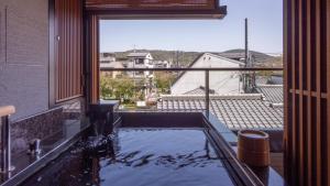 a bath tub with a view of a city at Sora Niwa Terrace Kyoto Bettei in Kyoto